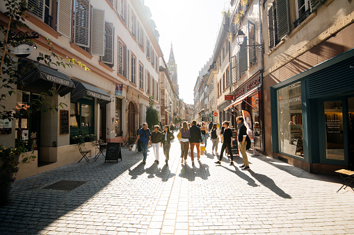 Strasbourg, France - Sep 21, 2019: Street view cityscape of Rue des Juifs street with shops people restaurants and Notre-Dame de Strasbourg cathedral in background