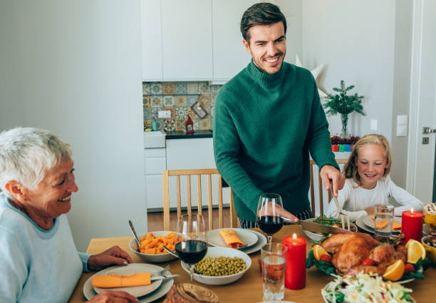 famiglia felice che mangia tacchino arrosto - turkey carving portion dinner foto e immagini stock