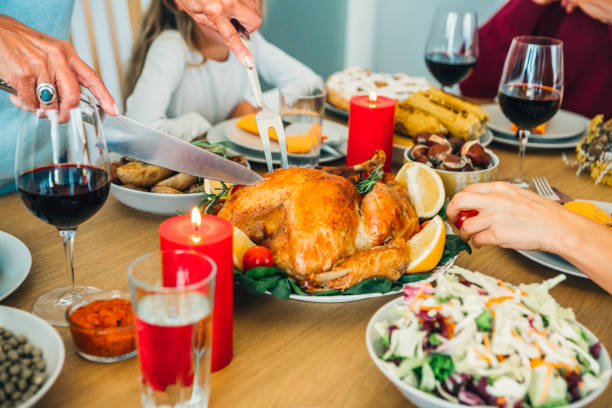 istock Unrecognizable person cutting roasted turkey during holiday dinner at dining table. 1181690572