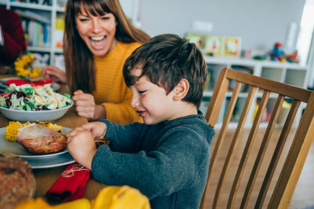 istock Happy mother and her son having fun while eating turkey leg 1181690635