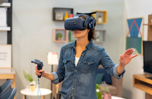 Latin american woman at home having fun with a virtual realit headset and joystick Latin american woman at home having fun with a virtual realit headset and joystick - Lifestyles virtual reality simulator photos stock pictures, royalty-free photos & images