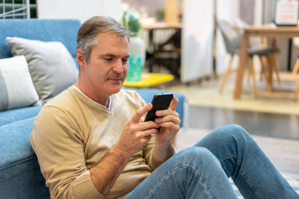 istock Adult man at home relaxing while chatting on smartphone 1181690883