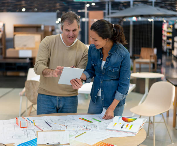 istock Happy couple looking at a design on tablet working on a home renovation project at a furniture store 1181691105