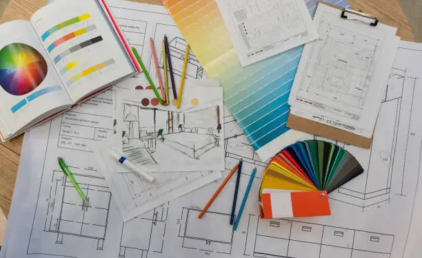 Photo of Blue prints, color swatch, pencil colors, sketches, plans and documents for a home renovation