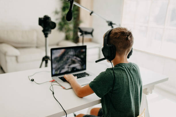 istock Boy in headphones playing video game on laptop 1181691619