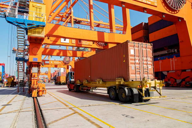 frachtschiff wird mit containern im hafen beladen. - semi truck cargo container shipping truck stock-fotos und bilder
