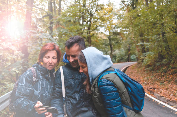 istock Three friends taking selfie before hiking.Cheerful people using smart phone in nature 1181697724