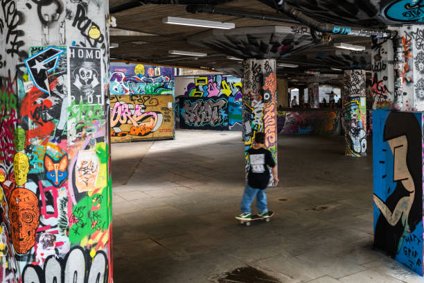 skateboarder in london von graffiti umgeben - skateboard park ramp skateboard graffiti stock-fotos und bilder