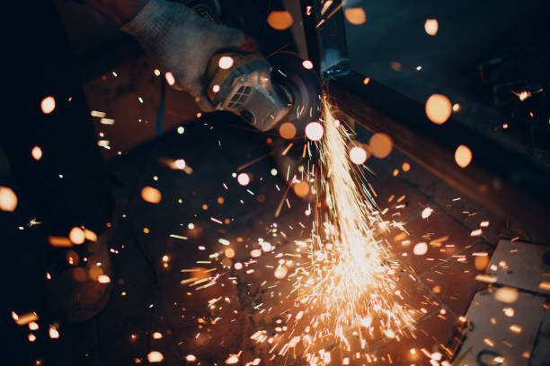istock Craftsman sawing metal with disk grinder saw in workshop 1181701175