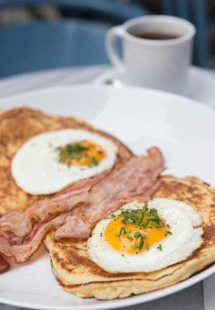 istock Breakfast with bacon, eggs, pancakes and coffee on white marble table 1181706351