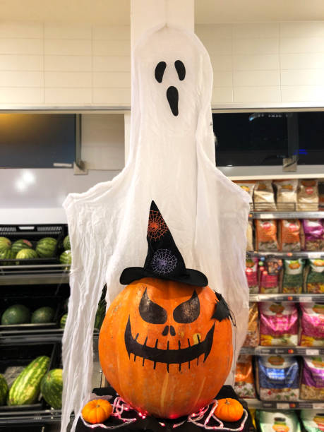 istock Jack o lantern pumpkins with hat in store. 1181707274