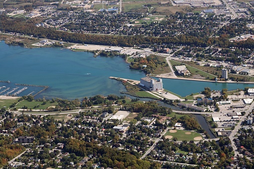 Looking down from small plane at blue water of Georgian Bay and grain elevators  houses and streets at the mouth of the Owen Sound harbor