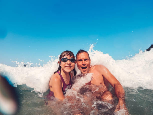 istock Father and daughter having fun on the beach 1181714599