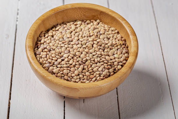 istock Uncooked green lentils on wooden black table 1181716497
