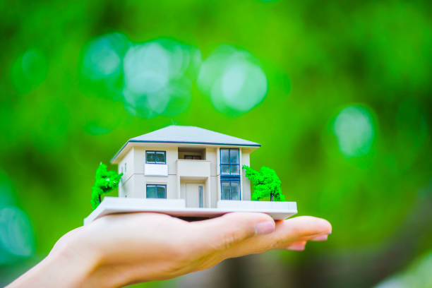 istock Green background with people with house model 1181716498
