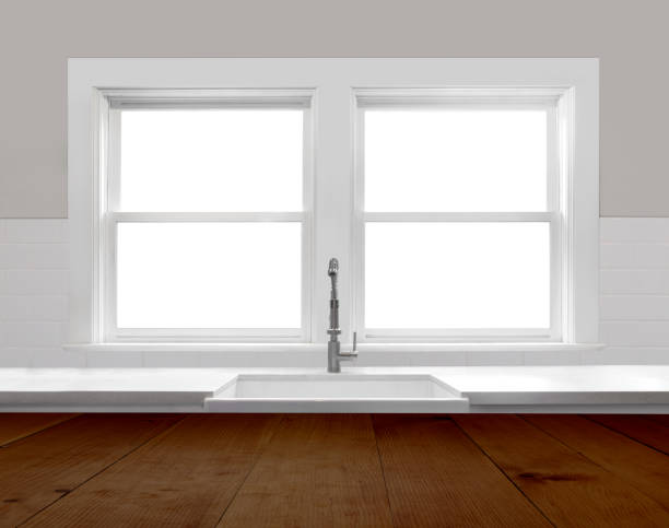 Modern farmhouse kitchen interior, looking out windows with subway tile, rustic island countertop and quartz