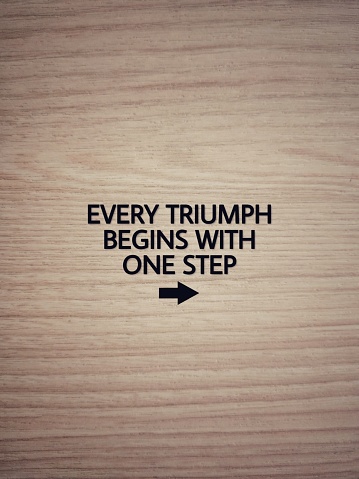 Every triumph begins with one step on wooden background stock photo