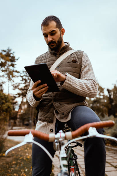 istock Man with a bicycle using digital tablet in the city park 1181721384