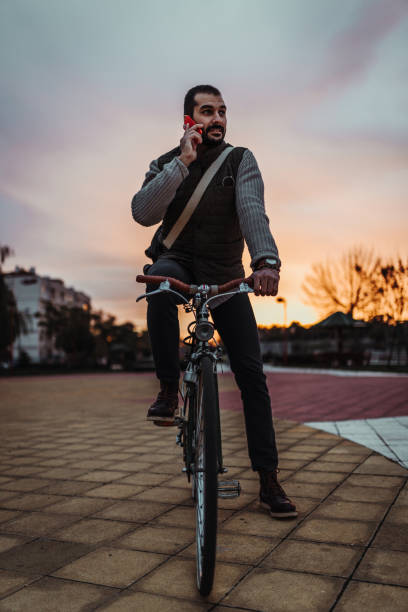 istock Man riding a bicycle and using phone in the park 1181721643