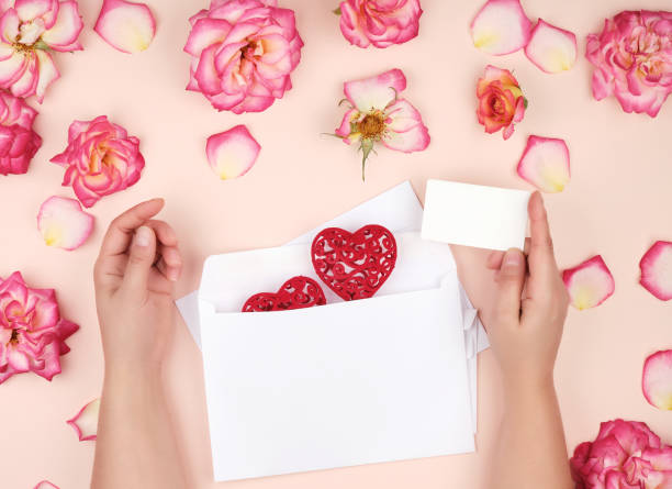 istock two female hands put a red heart in a white paper envelope 1181722979