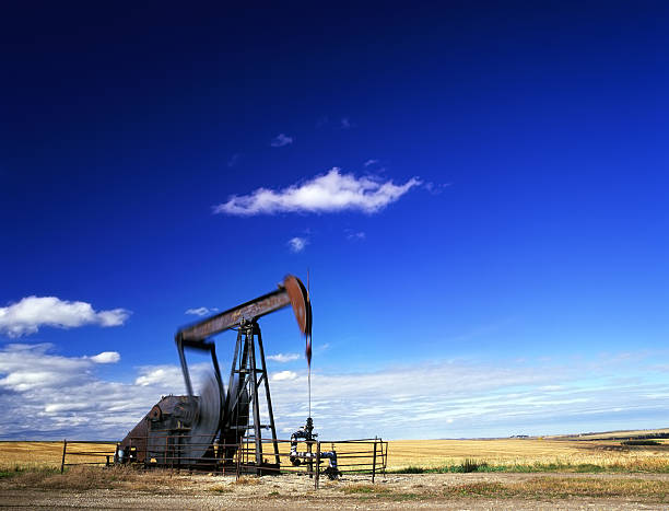 pumpjack in azione - oil pump oil industry prairie field foto e immagini stock