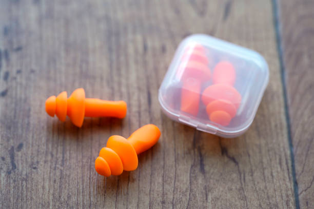 Orange earplugs to suppress sound Orange earplugs to suppress sound ear plug stock pictures, royalty-free photos & images