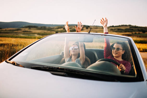 istock Young women having fun in convertible e at sunset 1181724614