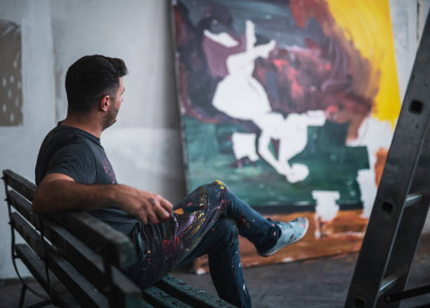 istock Young Artist working on big painting 1181729767