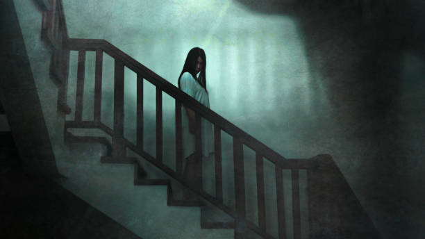 Japanese horror movie style portrait of young strange Asian girl at night in dark solitary hotel staircase looking weird and shady in fear and scary Halloween tribute stock photo