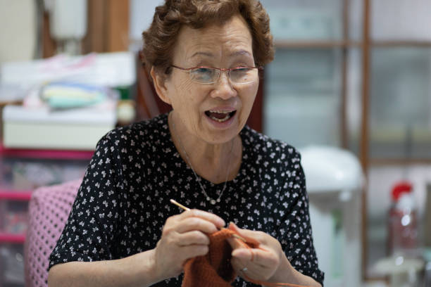 istock Elderly woman enjoying hobby knitting 1181763263