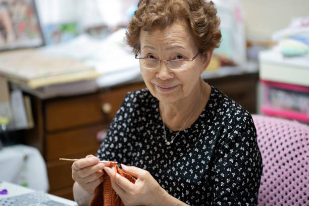 Elderly woman enjoying hobby knitting