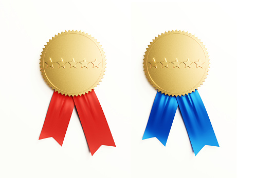 Gold medal pair isolated with red and blue ribbons on white background. Five stars imprinted on medals. Horizontal composition with copy space. Clipping path is included.
