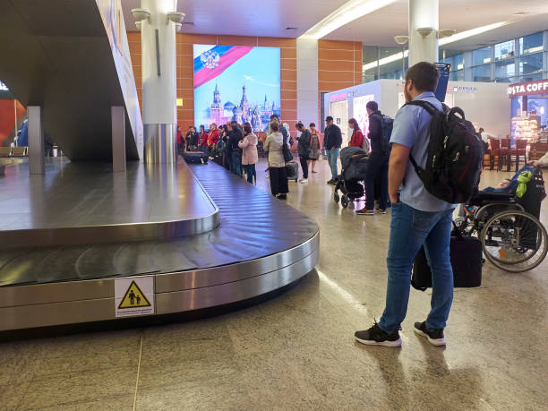 people are waiting for their luggage near the luggage carousel. sheremetyevo airport, russia - may 2019 - sheremetyevo imagens e fotografias de stock