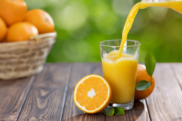 istock orange juice pouring in glass 1181767506