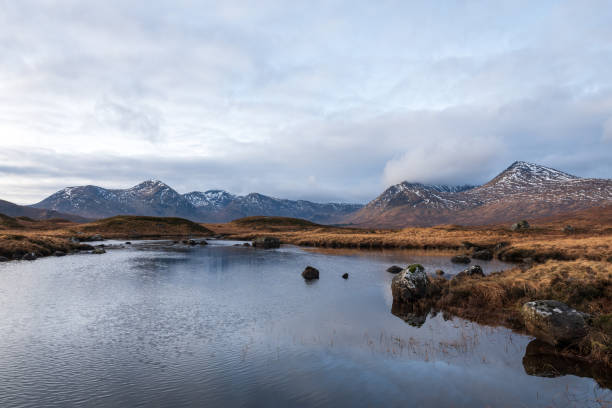 schottisches hochland über blick auf das black mount gebirge - highlands region loch reflection mountain stock-fotos und bilder