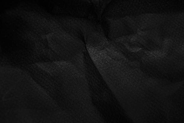 istock black wrinkled paper texture  background. Crumpled black paper surface 1181781228