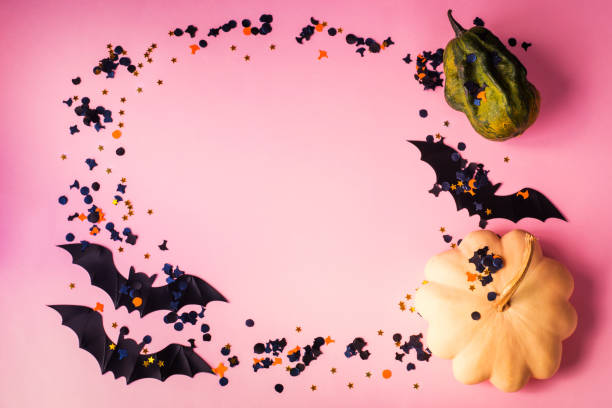 istock Halloween pumpkin and bat with confetti on pink 1181781490