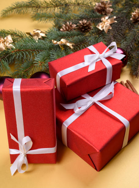 istock Christmas background with red gift boxes, fir tree branches with glass balls, pine cones and cinnamon sticks on golden background, free space. Red luxury New Year gift, copy space 1181783084