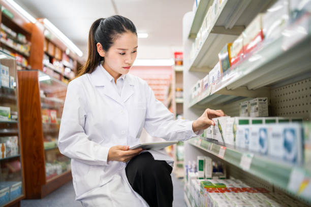 istock Female pharmacist managing shelves 1181794931