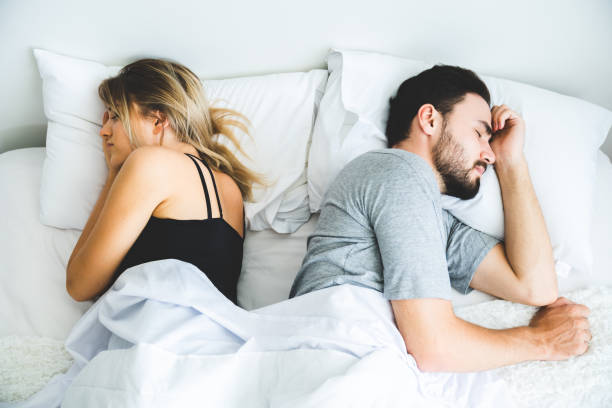 Sad lovers after quarrel  ignoring avoiding sex in bed, frustrated man and woman not talking feeling offended or stubborn, unhappy married couple and sexual problems concept stock photo