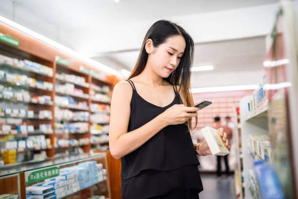 istock Female customer using a smart phone to scan QR code on a medicine box 1181797791