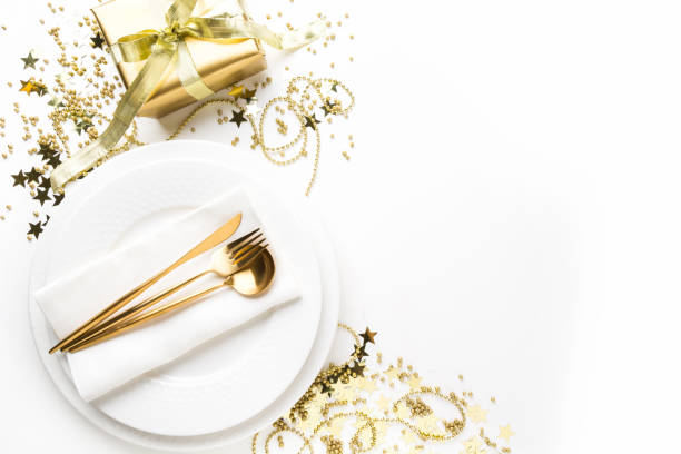 istock Christmas table setting with dishware, golden silverware on white background. Top view. 1181804359