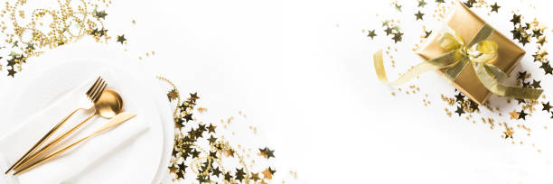 Christmas table setting with golden dishware, silverware on white background. Top view.