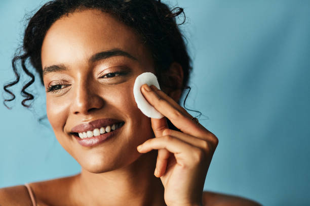 Healthy skin is not an over night process Studio shot of a beautiful young woman using a cotton pad on her face facial cleanser stock pictures, royalty-free photos & images