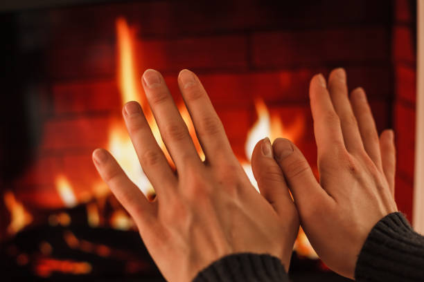 istock Hands warming up near fireplace 1181807153