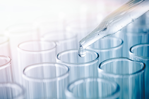 Doctor holds test tube with his hand , isolated on white background