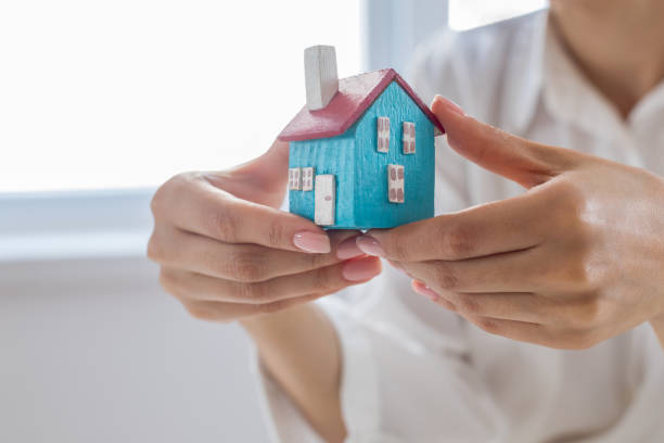 istock Woman hands presenting small model of house 1181807623