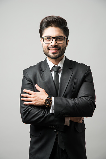 Indian Male businessman standing against gray background