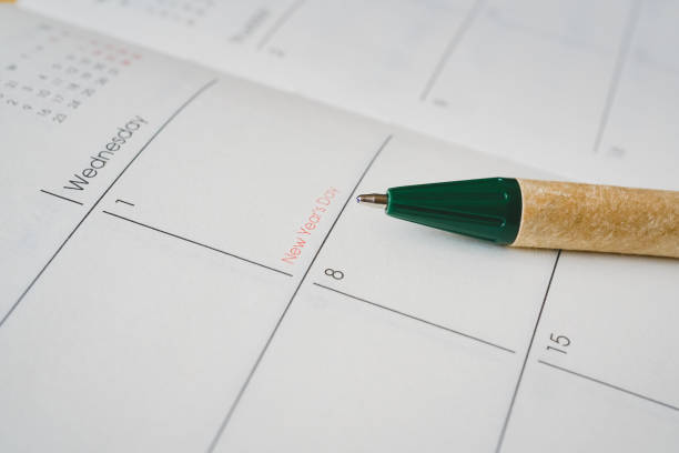 istock ball pen pointed at New Year's Day on opened planner page 1181808518