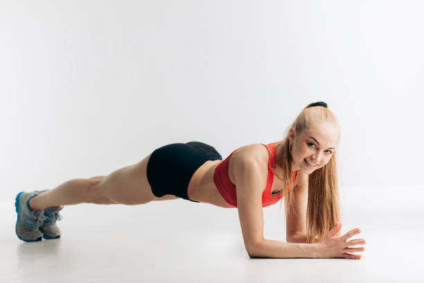 istock cheerful blonde athlete showing plank exercises for tight, flat abs 1181810566
